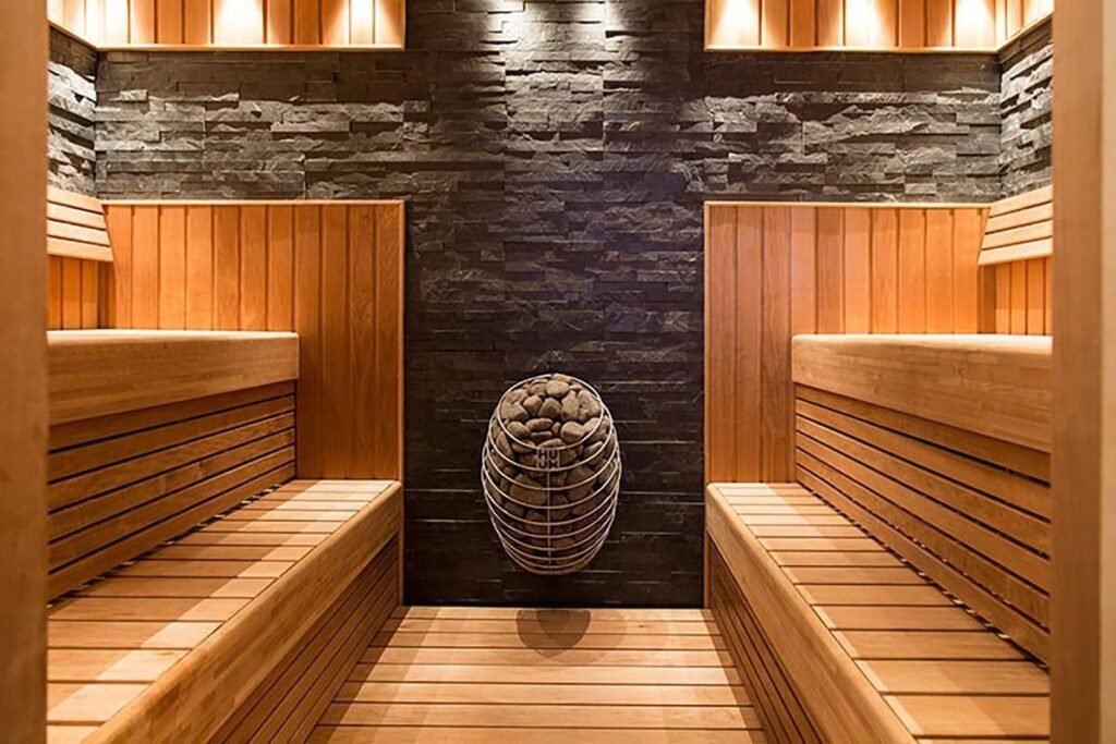 HUUM DROP heater on the end wall of a sauna with long timber benches