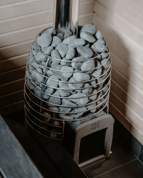 HUUM HIVE HEAT wood burning stove installed in the corner of a sauna